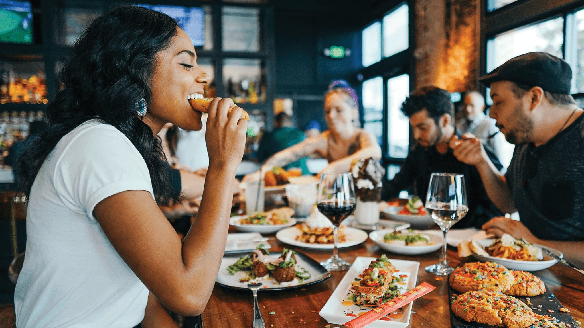 Una mujer cenando con sus amigas en un restaurante de moda